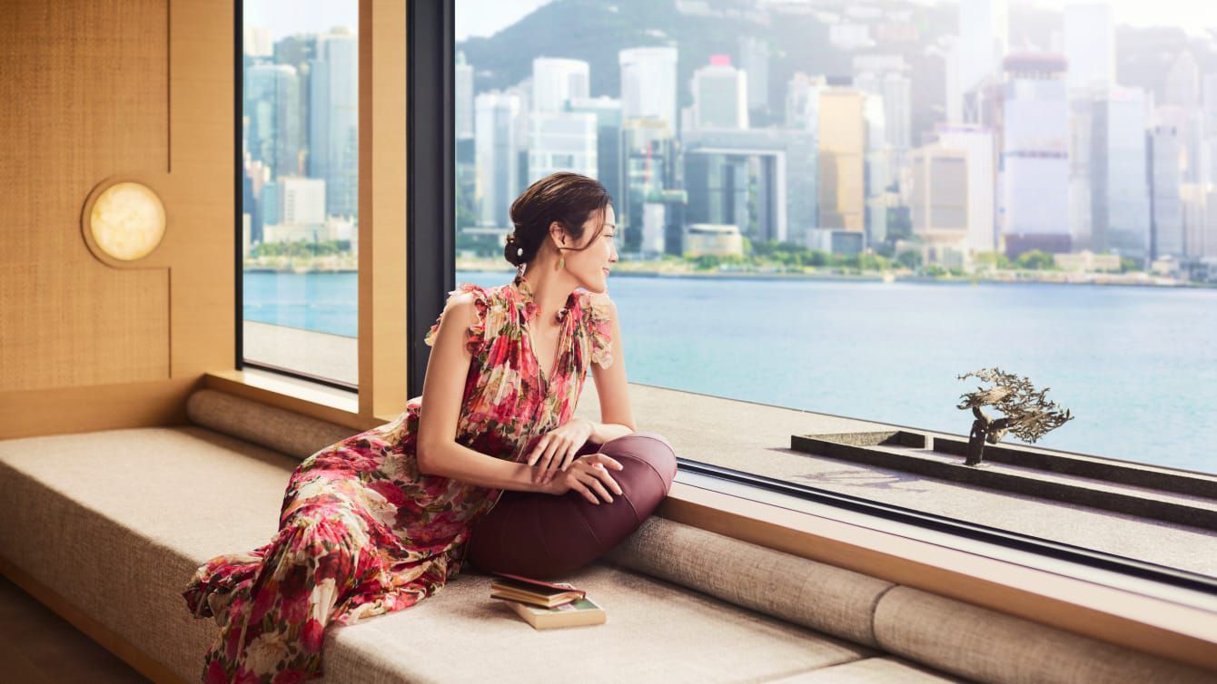 A beautiful young Asian woman enjoy the view of Victoria Harbor in Hong Kong.