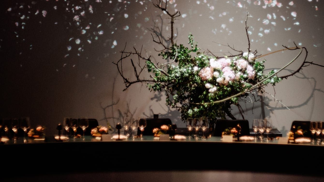 An immaculate table with a climbing floral arrangement of roses.