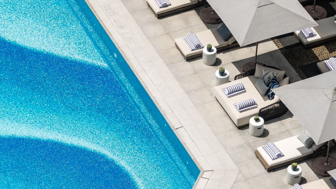 overhead view of a pool with umbrellas and luxurious chaise lounges