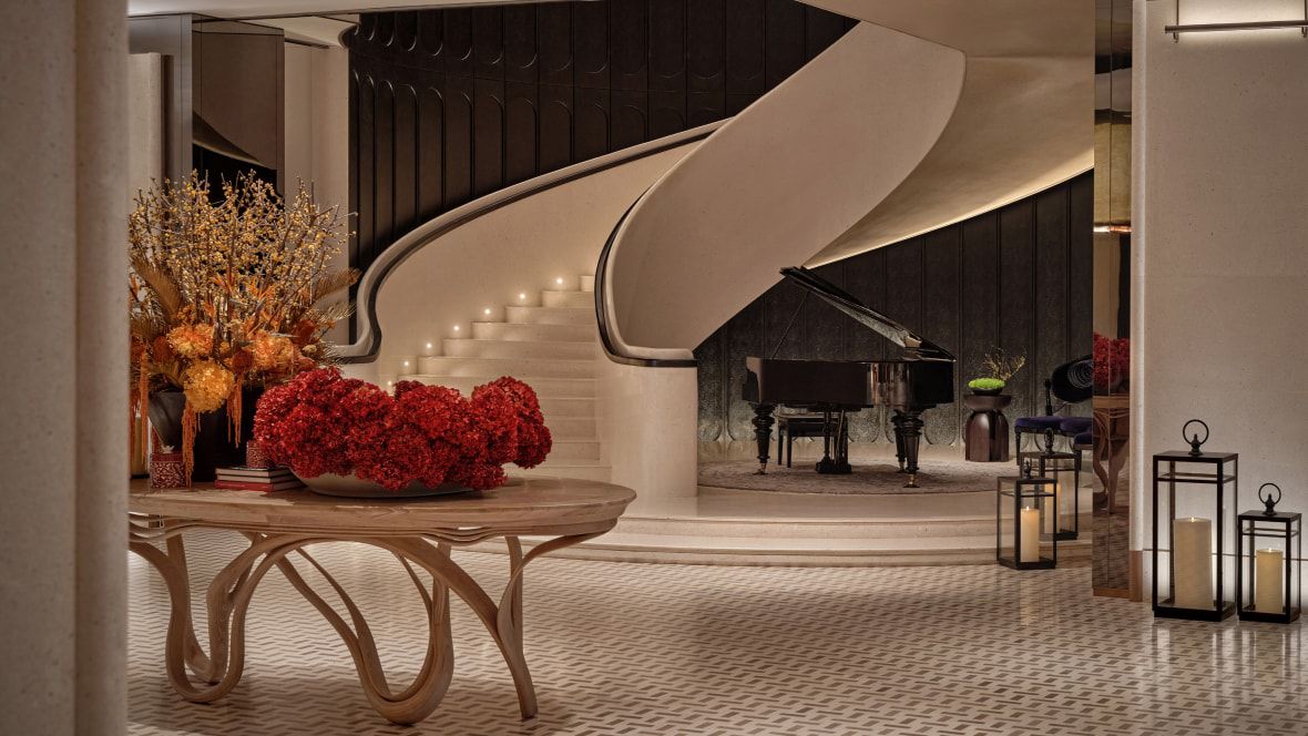 lobby with grand piano and curved staircase