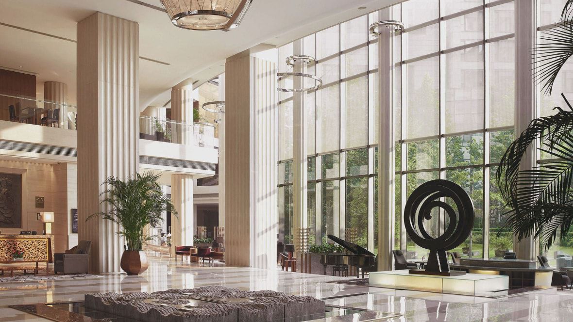grand lobby with sculpture, mezzanine and floor-to-ceiling windows
