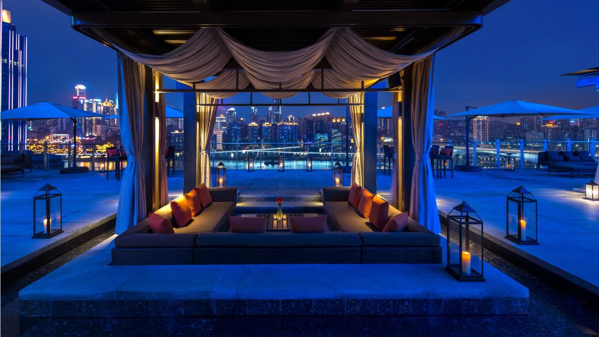 cabana at night with candlelit seating and city views