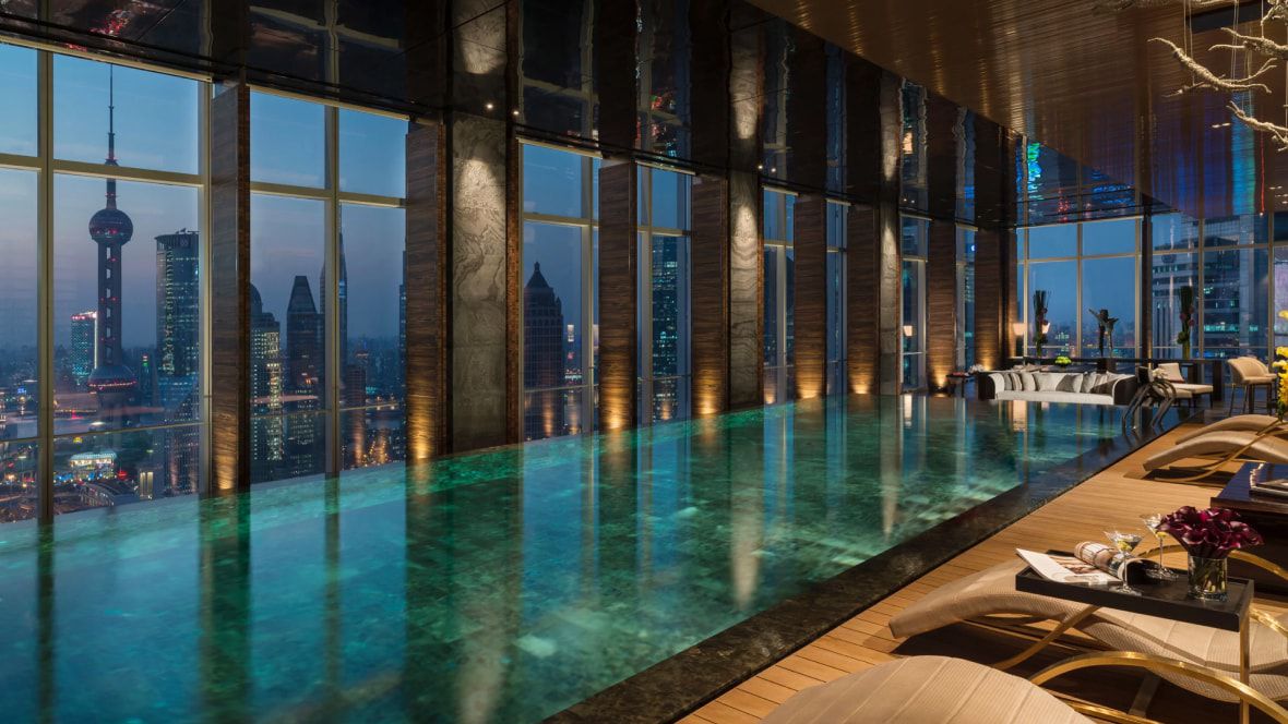 indoor pool in a high-rise overlooking city lights at night