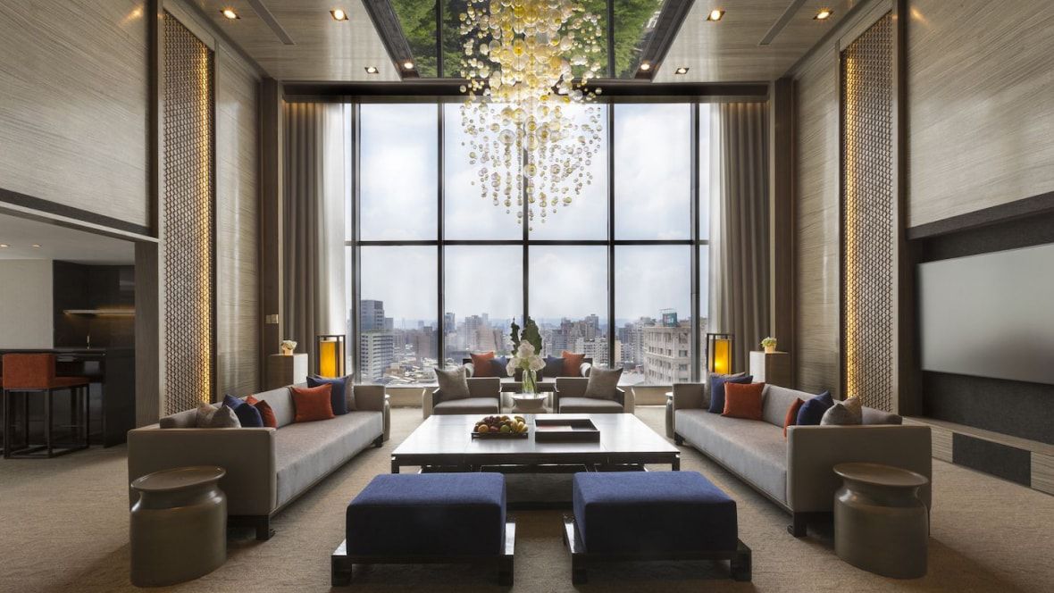 large seating area with dramatic chandelier and views of the city