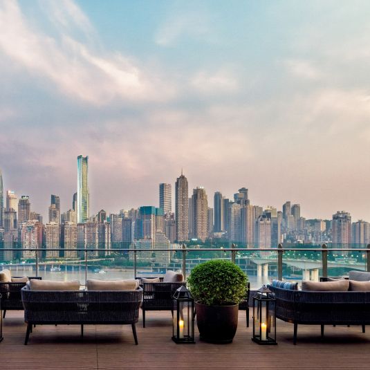A leafy park and flowing harbor meets an ultra-modern city skyline