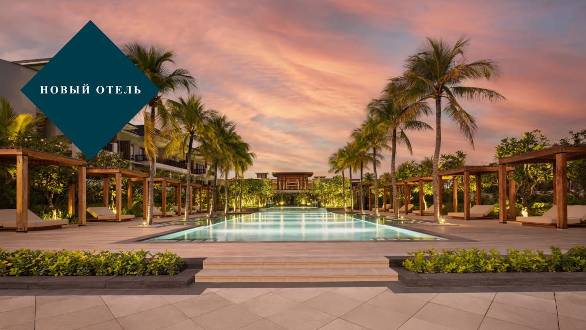 Фото бассейна, окруженного пальмами, в новом отеле Regent Bali Canggu, в сумерках