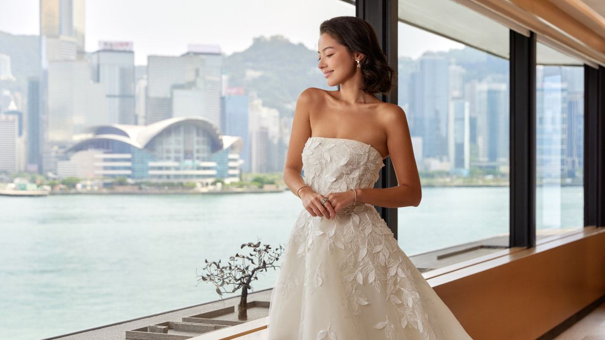 bride in wedding dress posing with city skyline in background