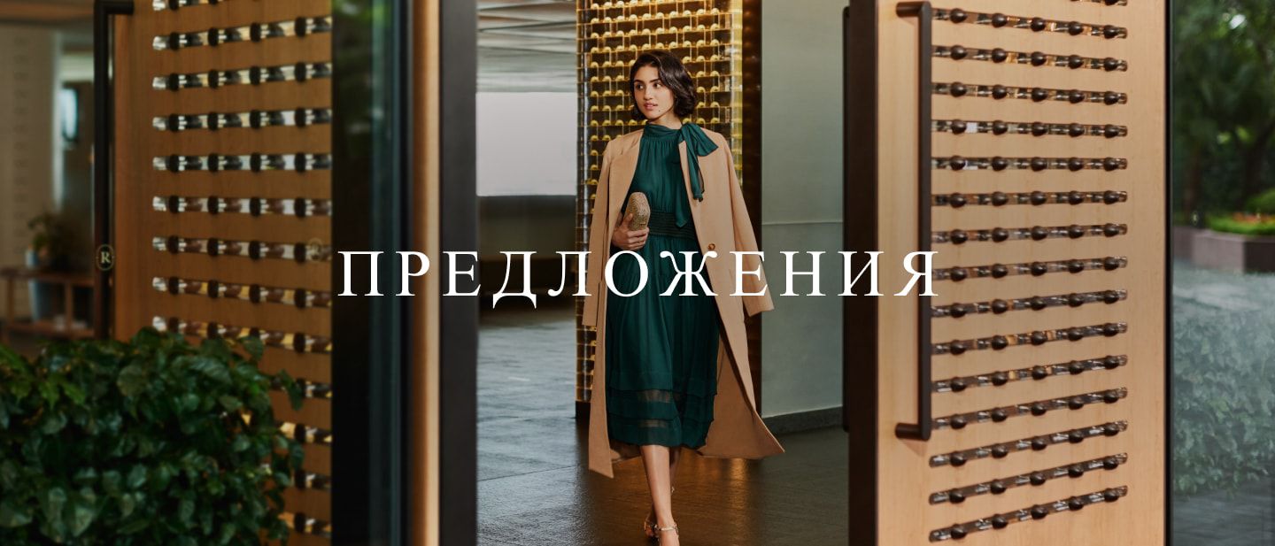 woman in a dress walking through doors into a lobby