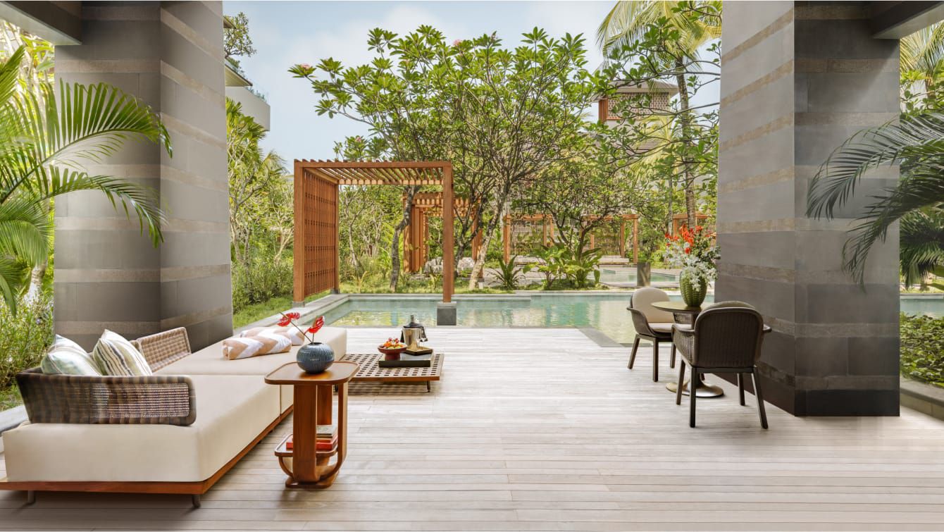 A modern guest room opens to the lagoon pool in Bali
