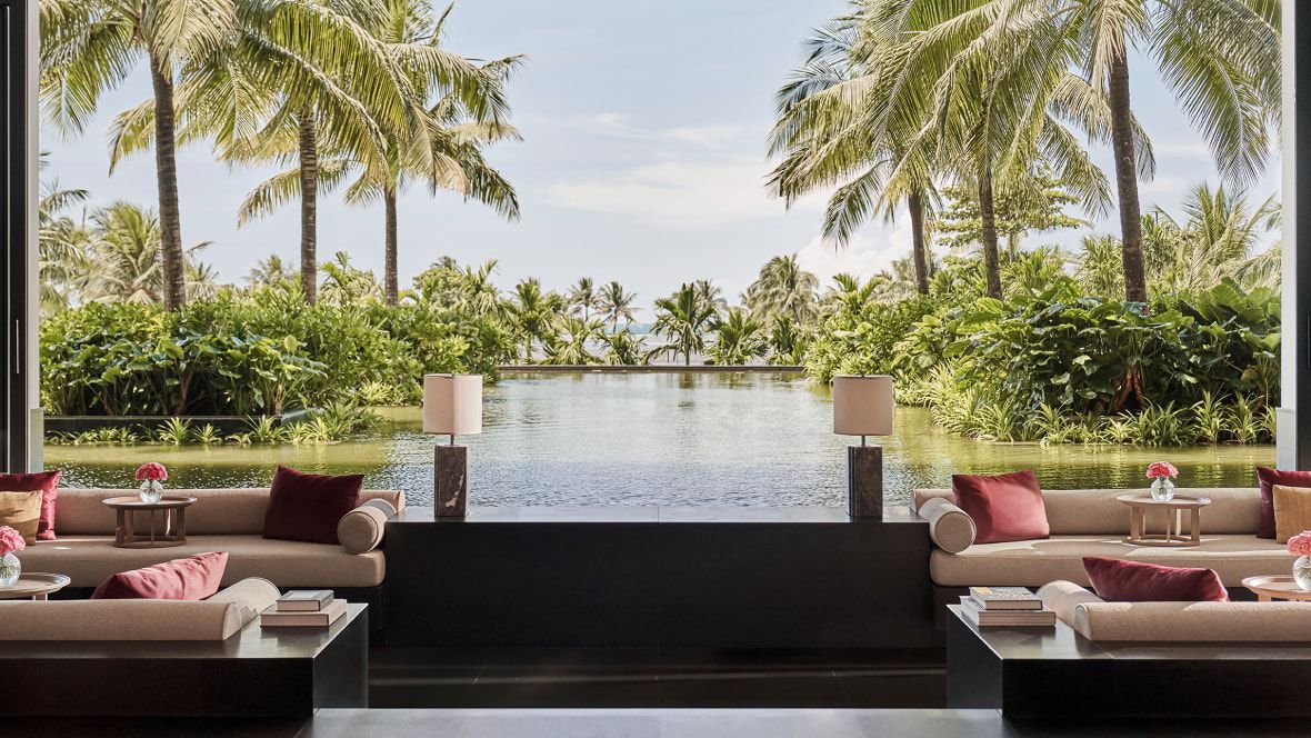 open air lounge overlooking water and palm trees