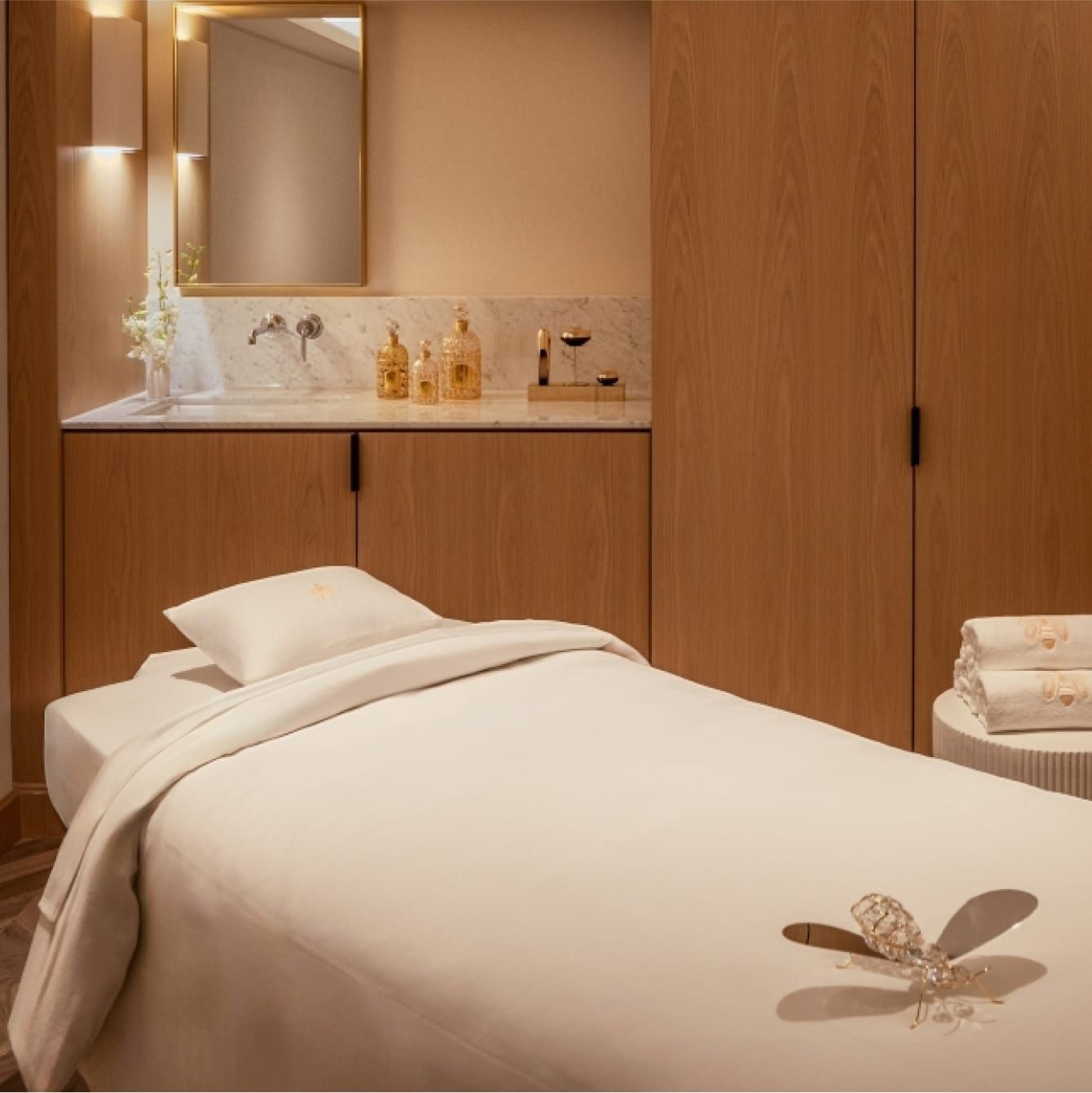 Phòng trị liệu spa được chiếu sáng tinh tế cùng giường mát-xa.