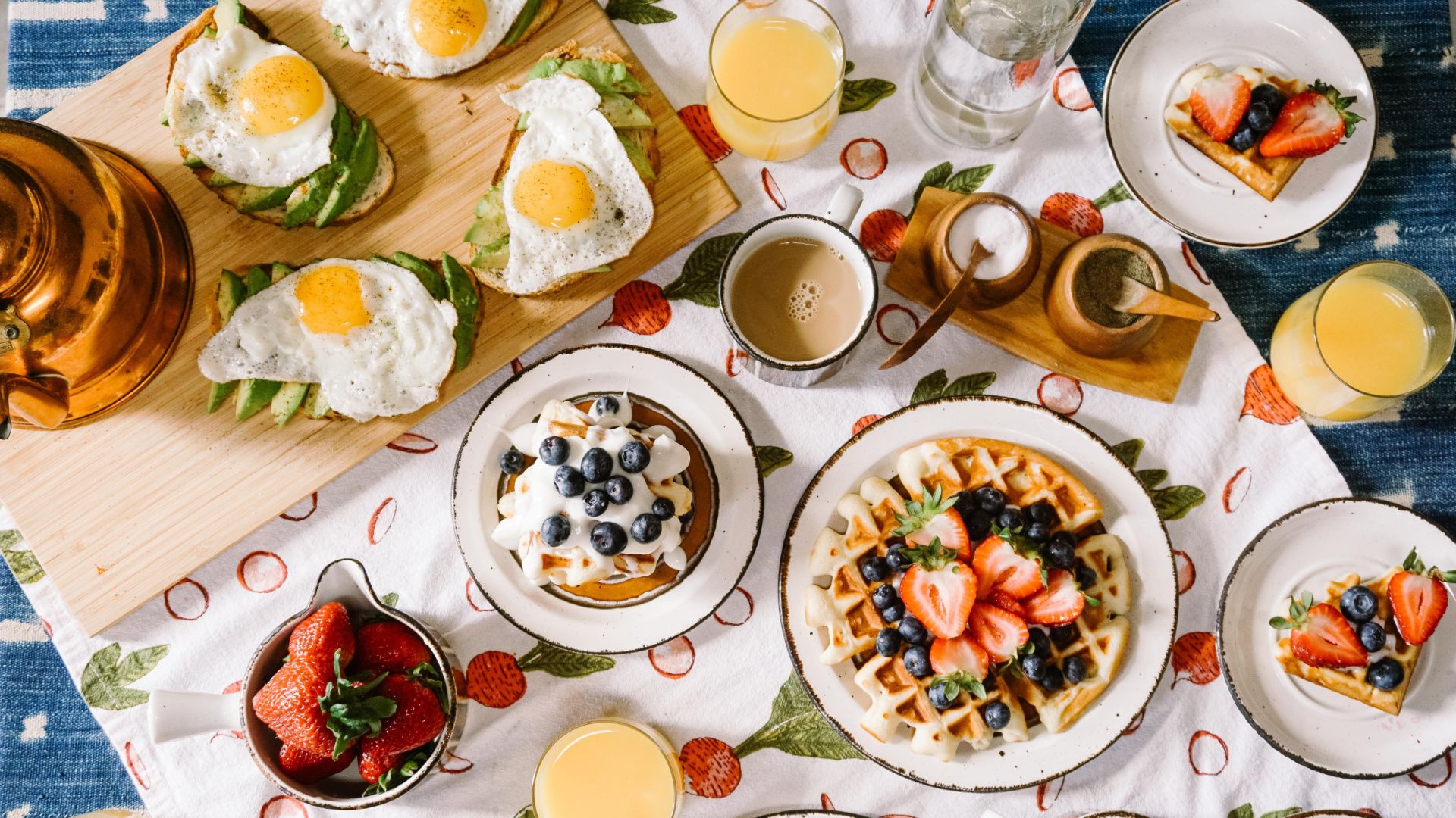 overhead view of a table filled with plates of breakfast food