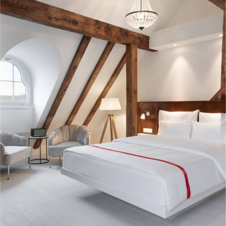 Clean bedroom with a bed and parlor chairs