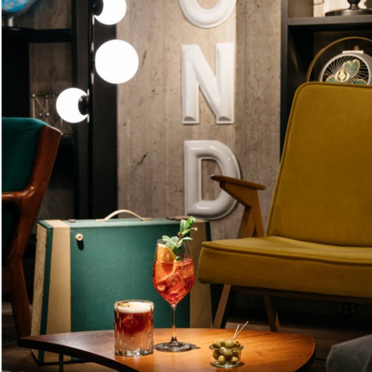 Lounge chair facing cocktails and olives on a coffee table