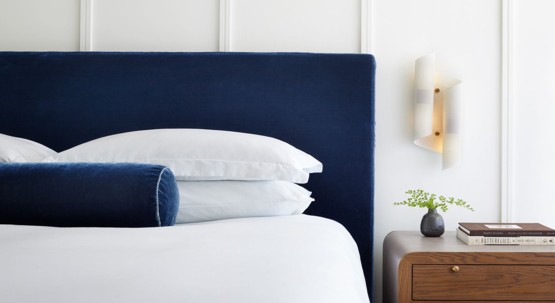 bright white buestroom with blue accent pillow on the bed