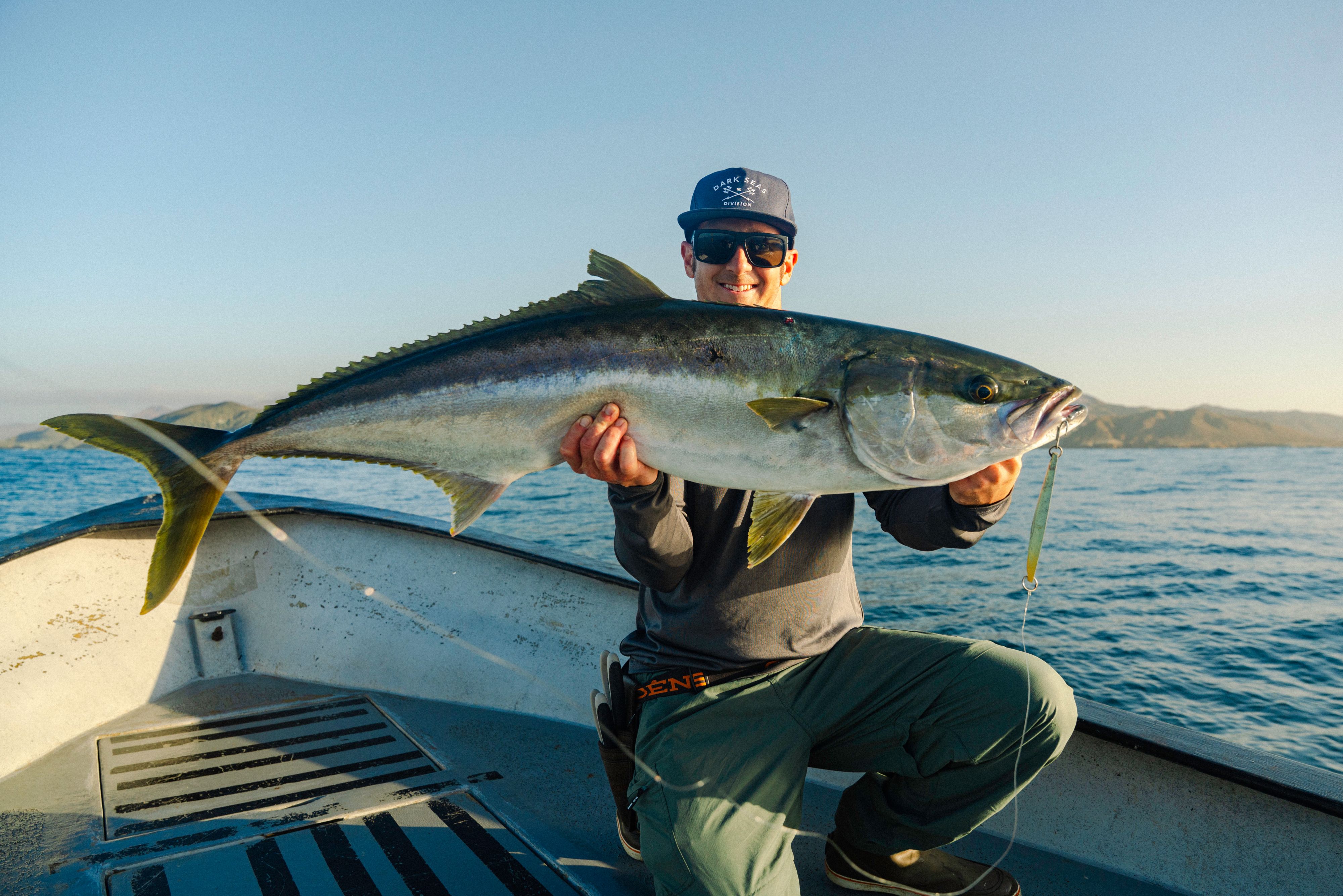 man holding fish on boat