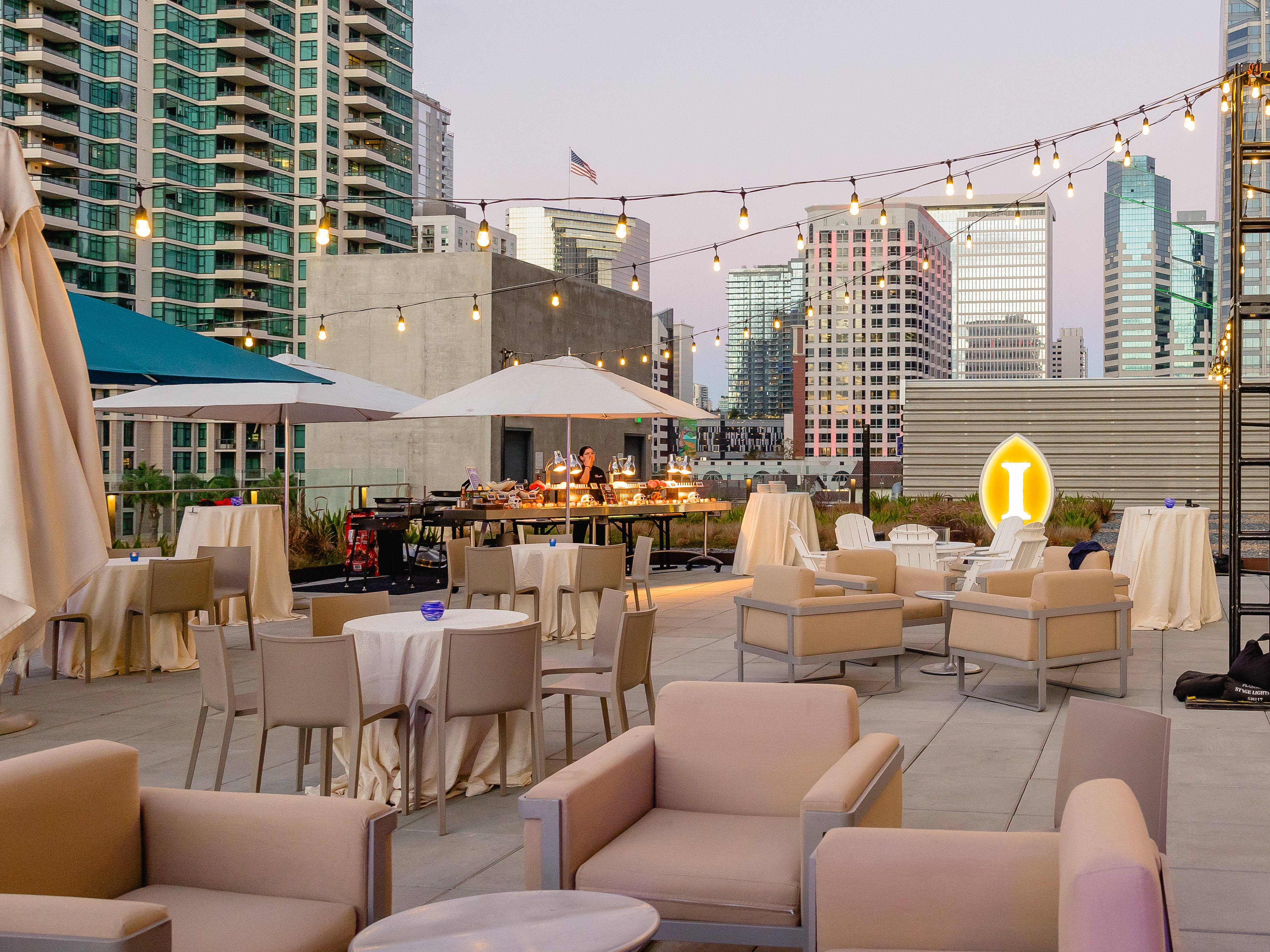 Rooftop terrace with seating and city skyline at dusk