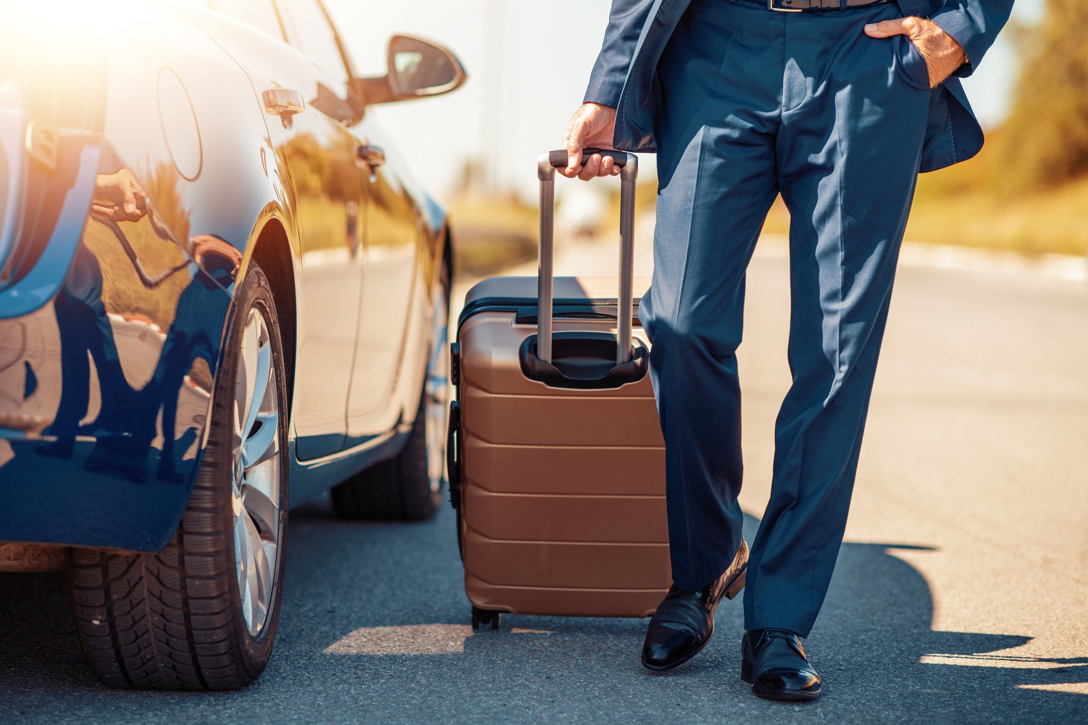 Guest with luggage walking beside a parked vehicle