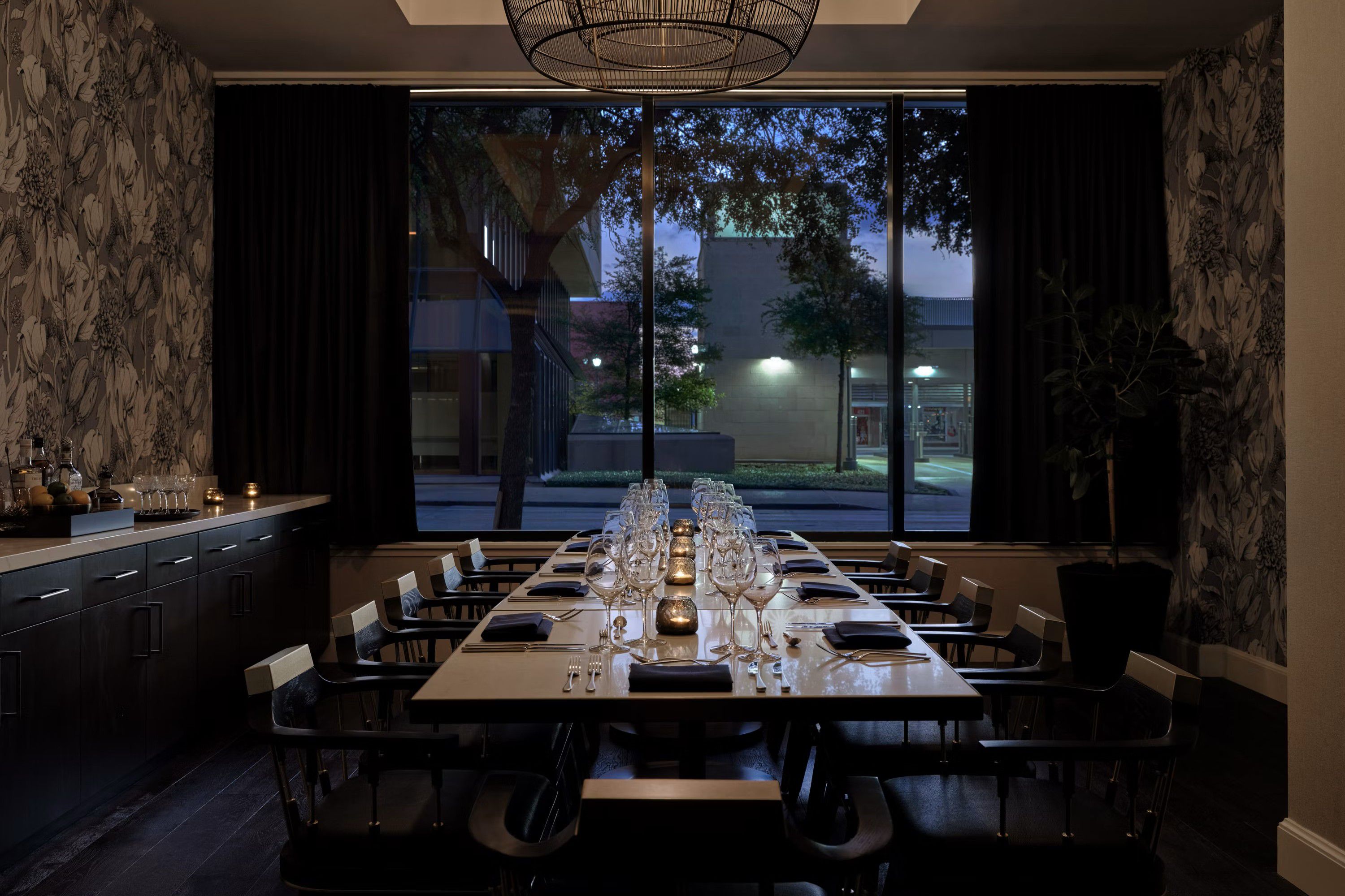 Private dining room with a long table, elegant place settings, and floor-to-ceiling windows.