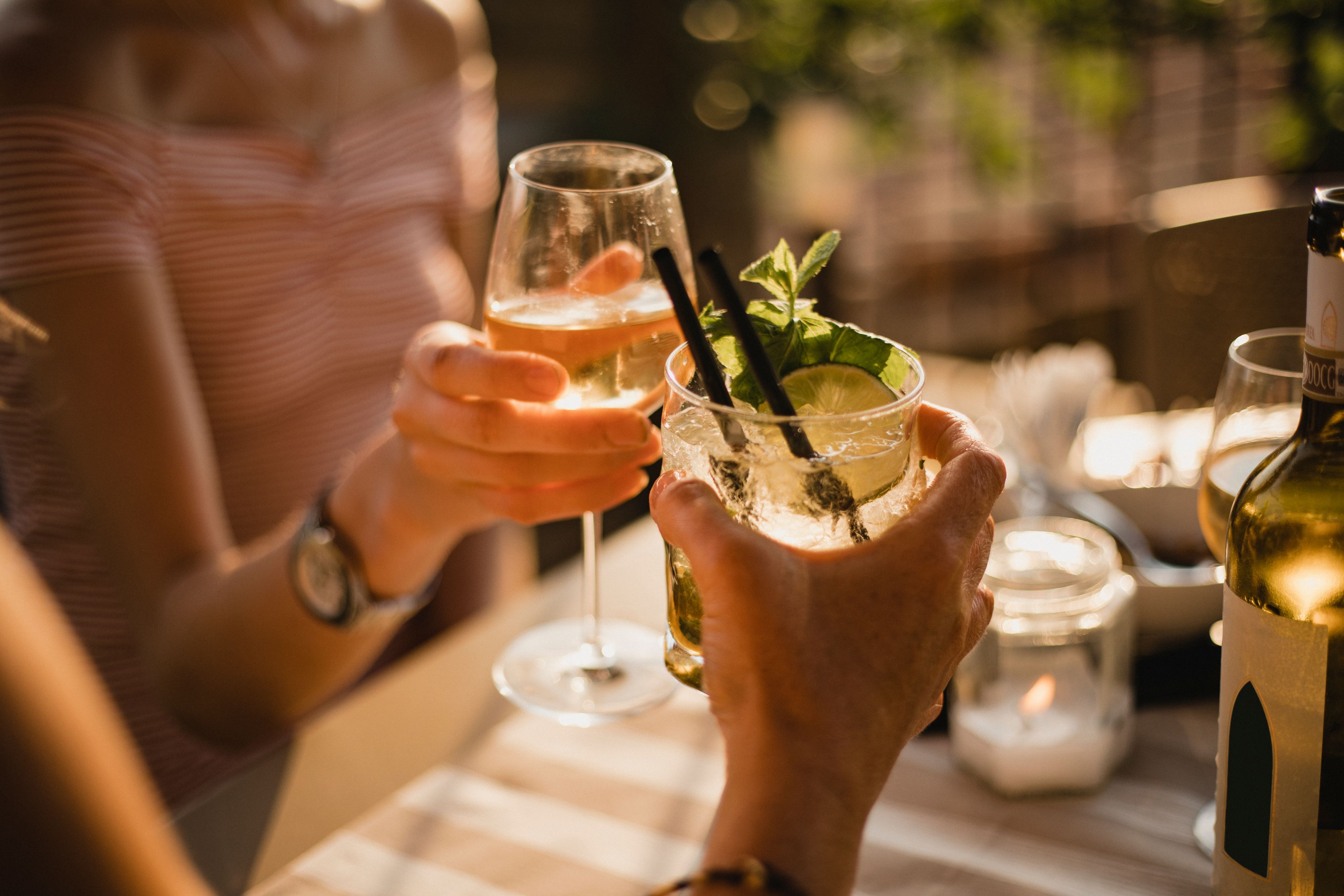 Cocktails garnished with lime and mint served during an outdoor gathering.