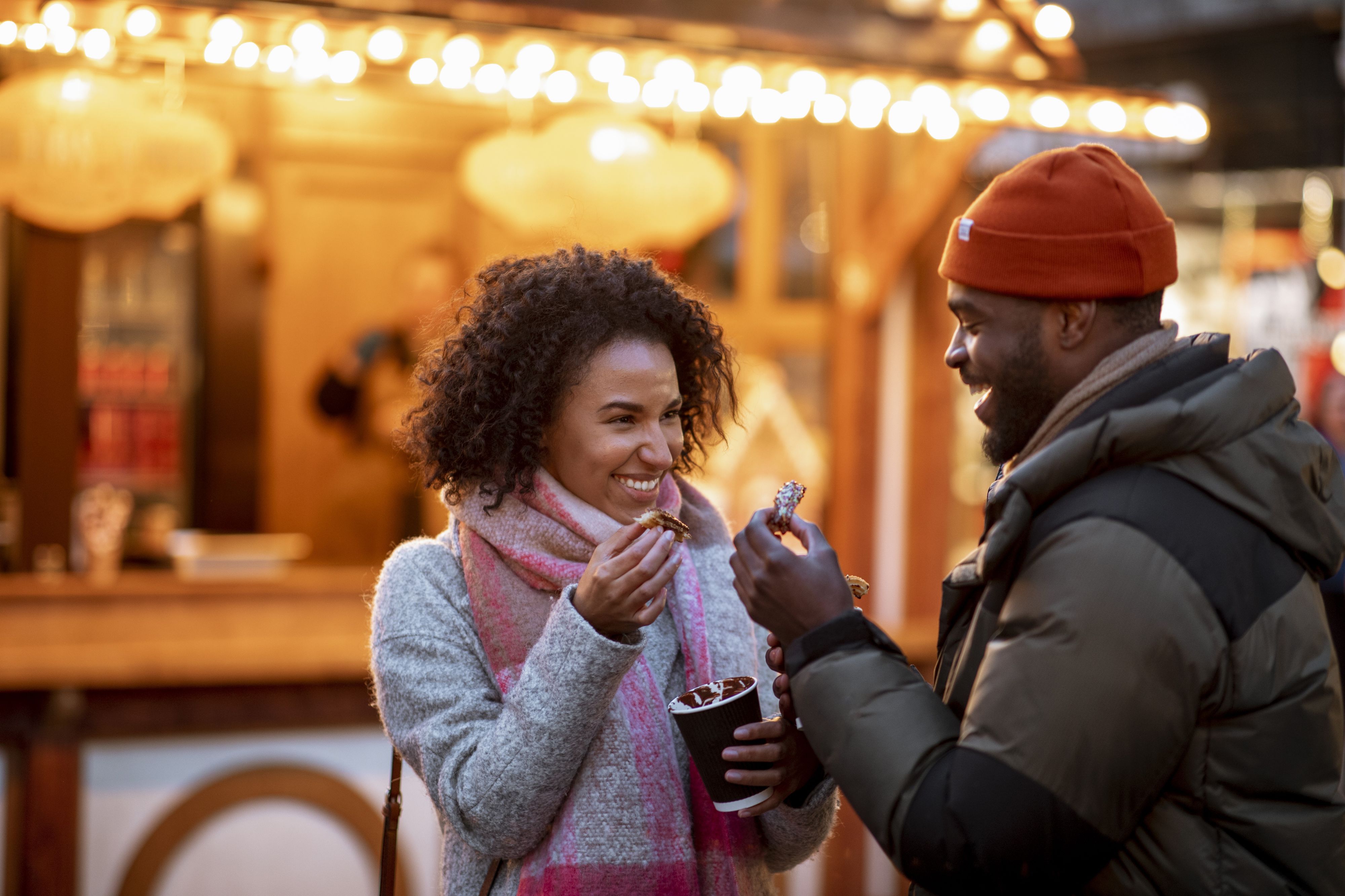 Guests enjoying warm drinks at an outdoor holiday market