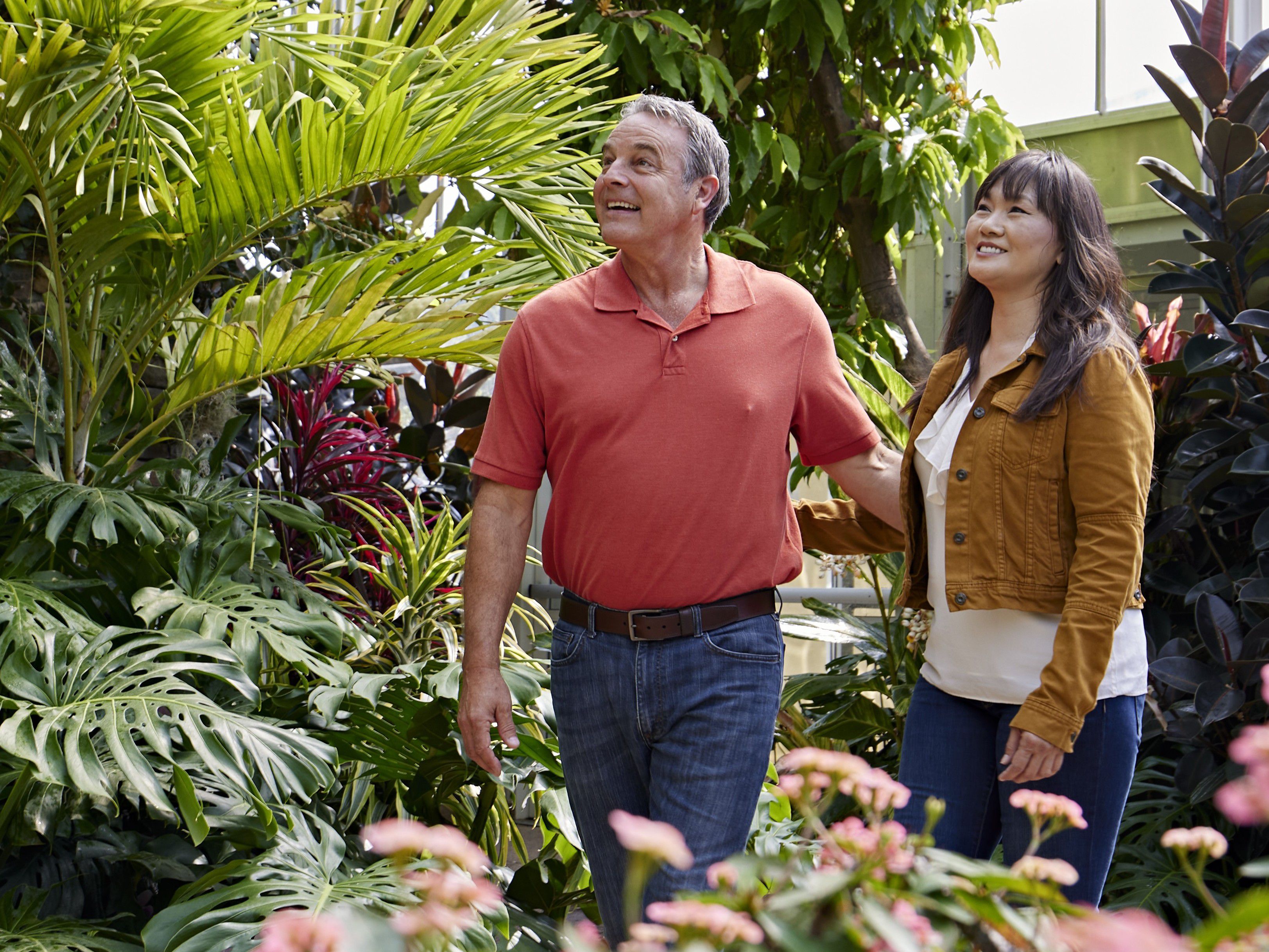 Visitors explore a lush indoor botanical garden with a waterfall.