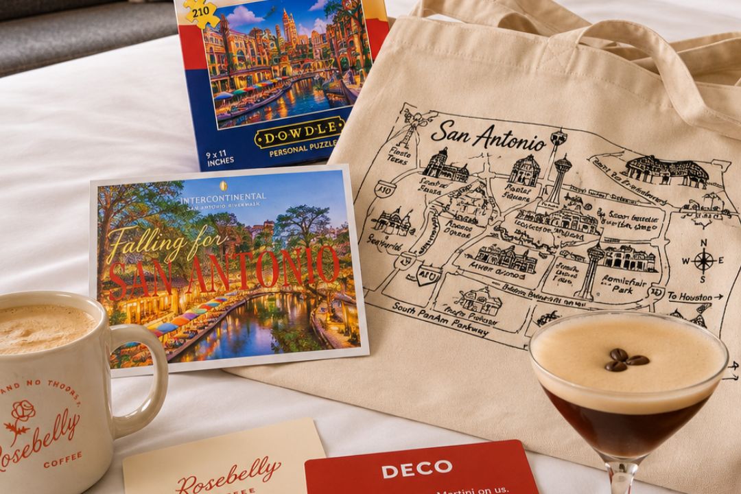 San Antonio-themed welcome amenities featuring a city map tote bag, local puzzle, postcard, coffee, and espresso martini.