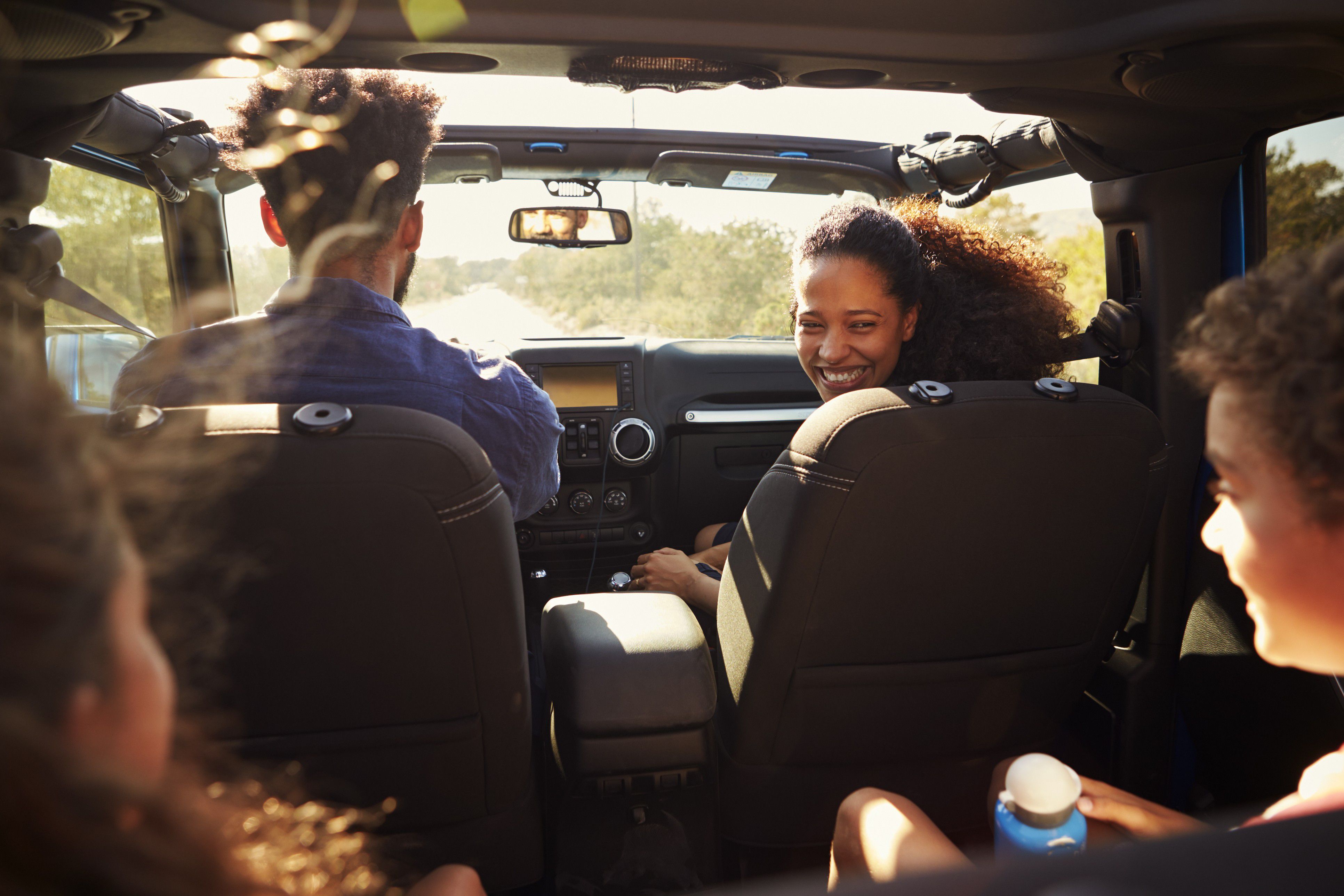 Family enjoying a scenic drive together in an open-air vehicle.