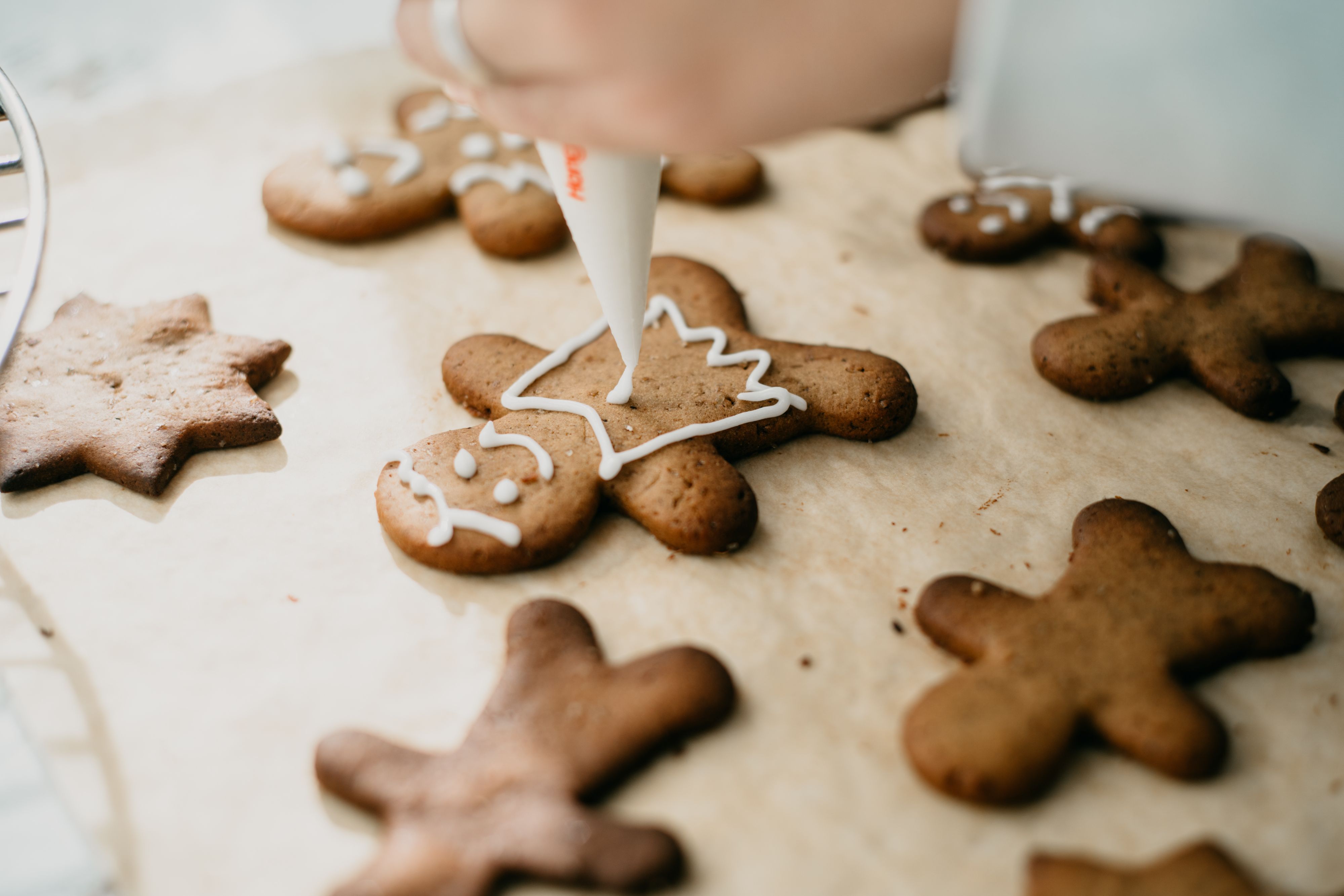 Person decorating gingerbread cookies