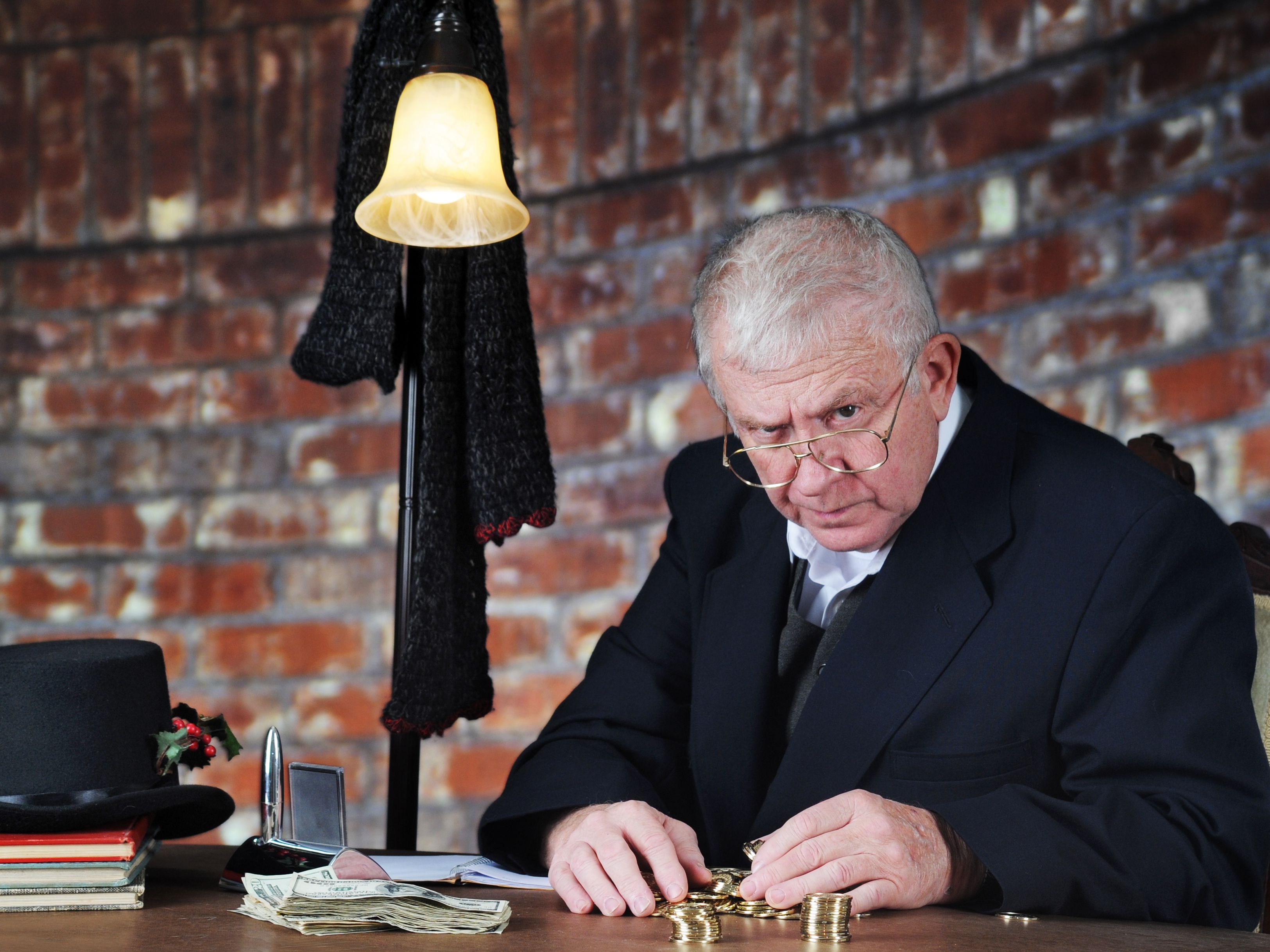 Grumpy old man counting coins scowling