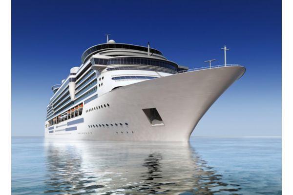 luxury white cruise ship shot at angle at water level on a clear day.