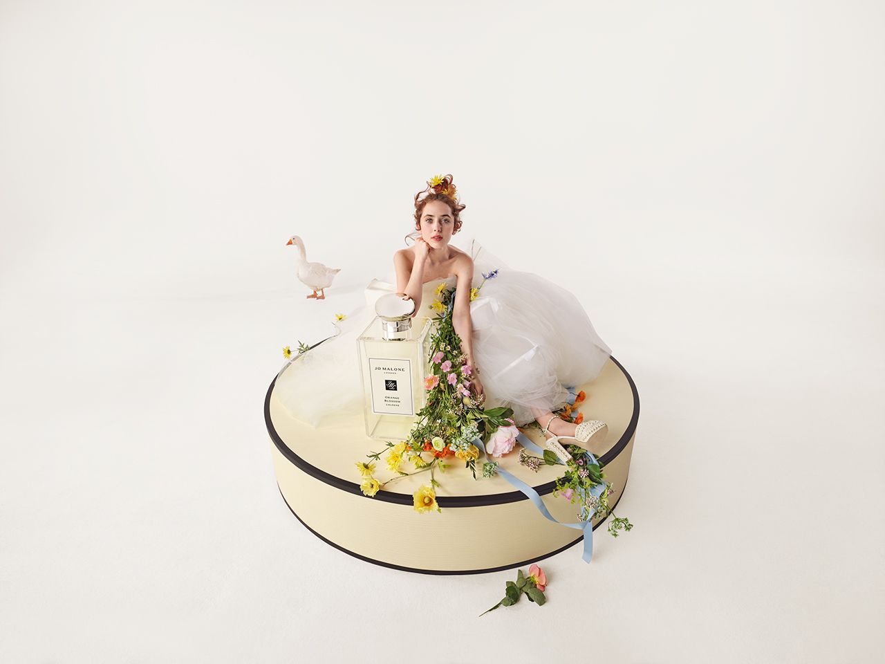 Woman sitting with a Jo Malone bottle 