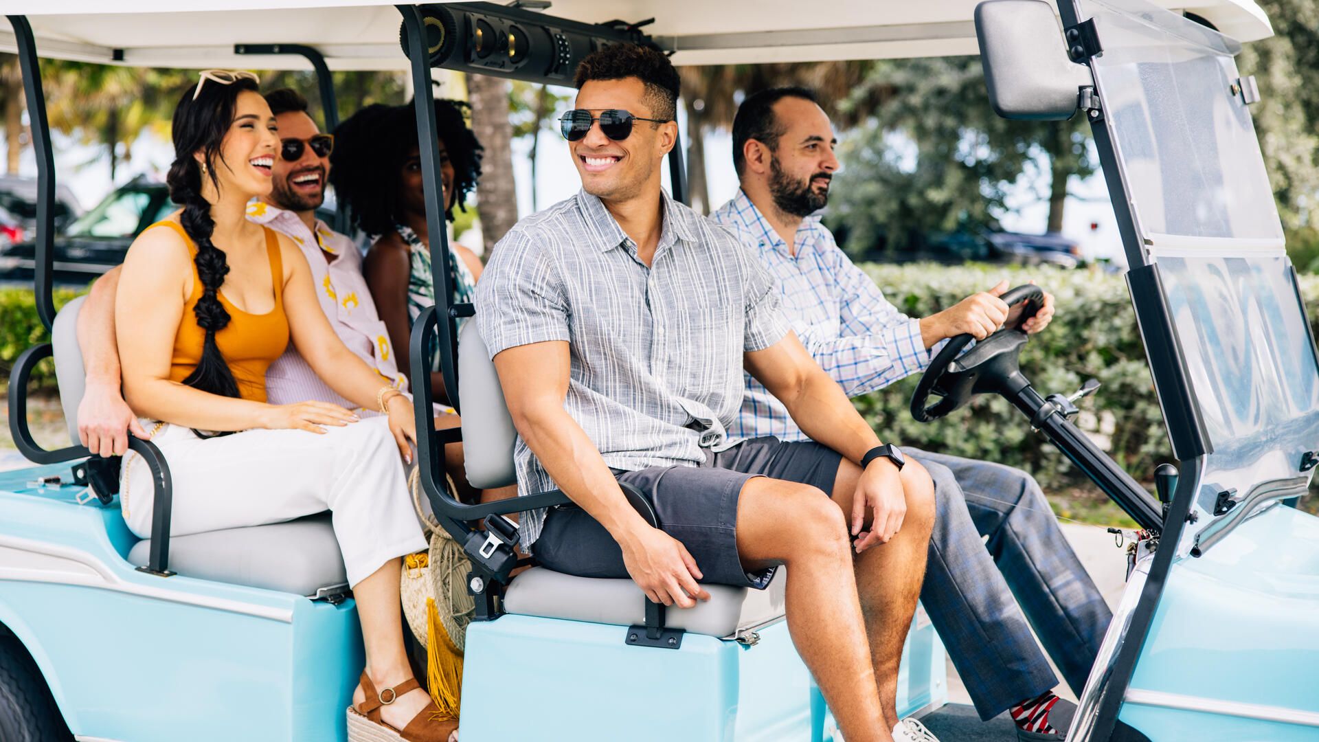 four people riding in a golf cart in florida