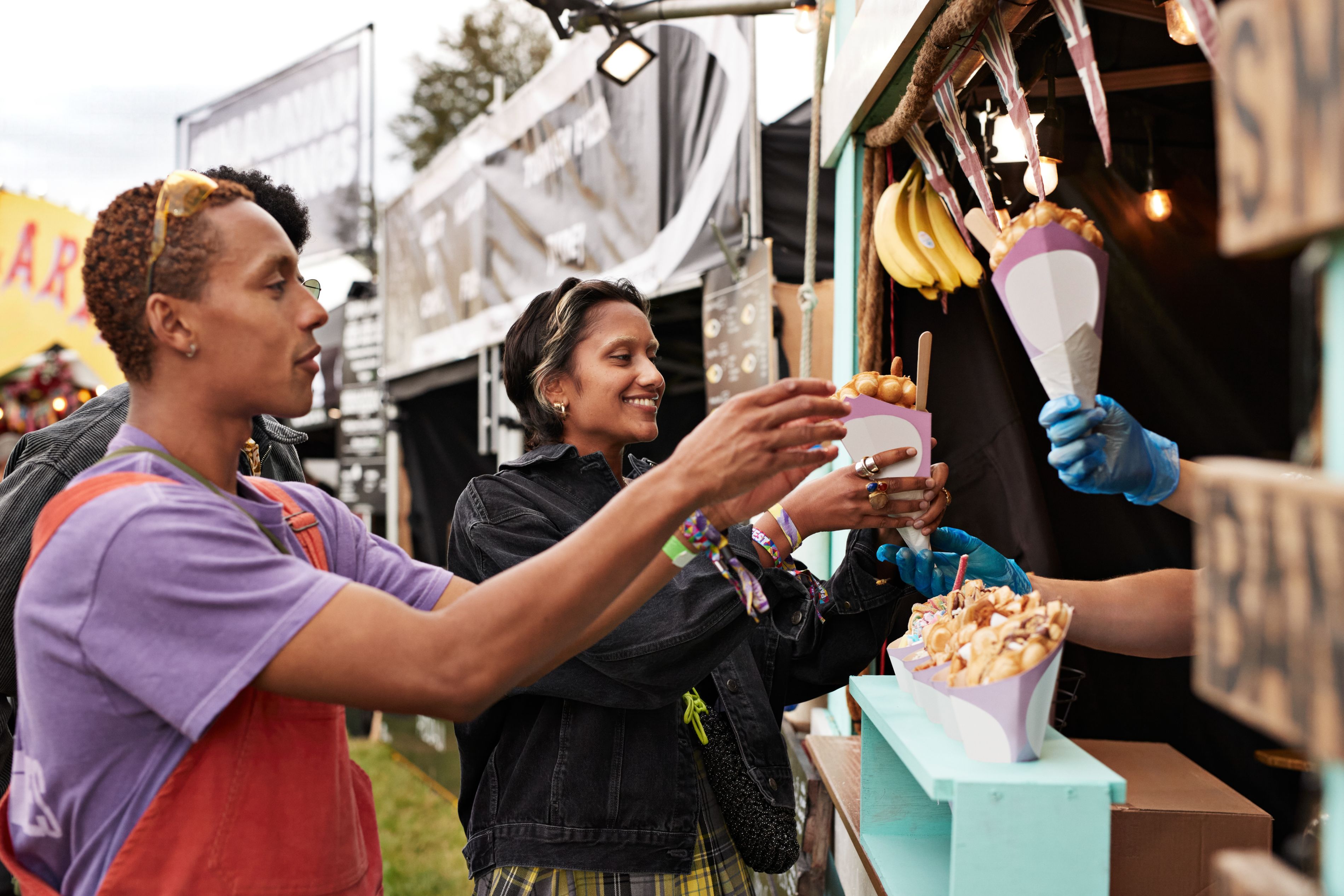 People getting food from street food vendor.