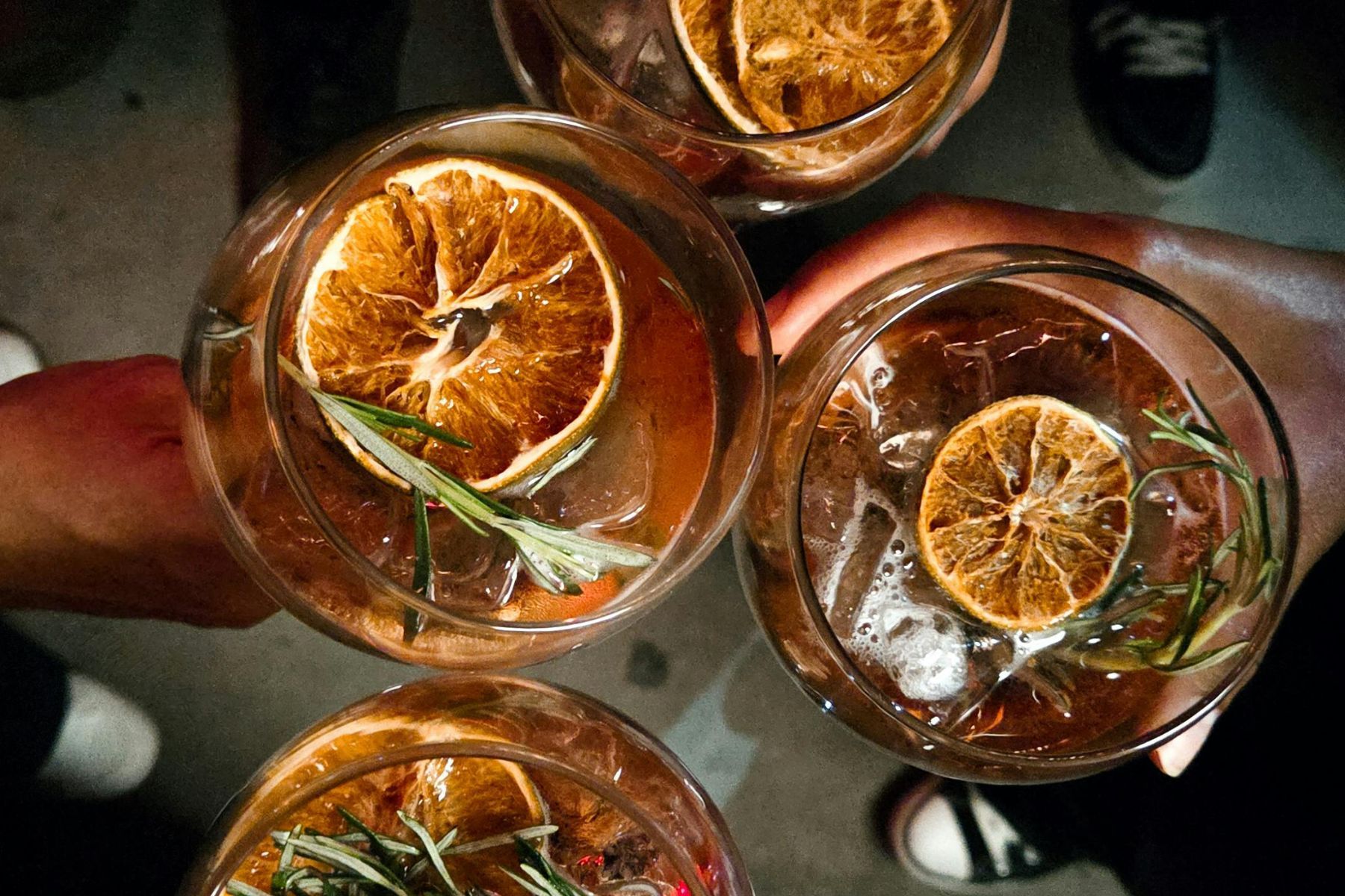 Cocktails garnished with dried citrus and thyme.