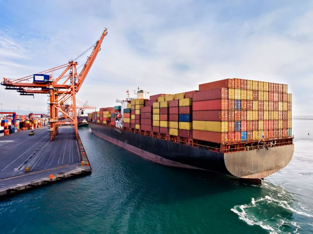 Boat with shipping containers docked at a port