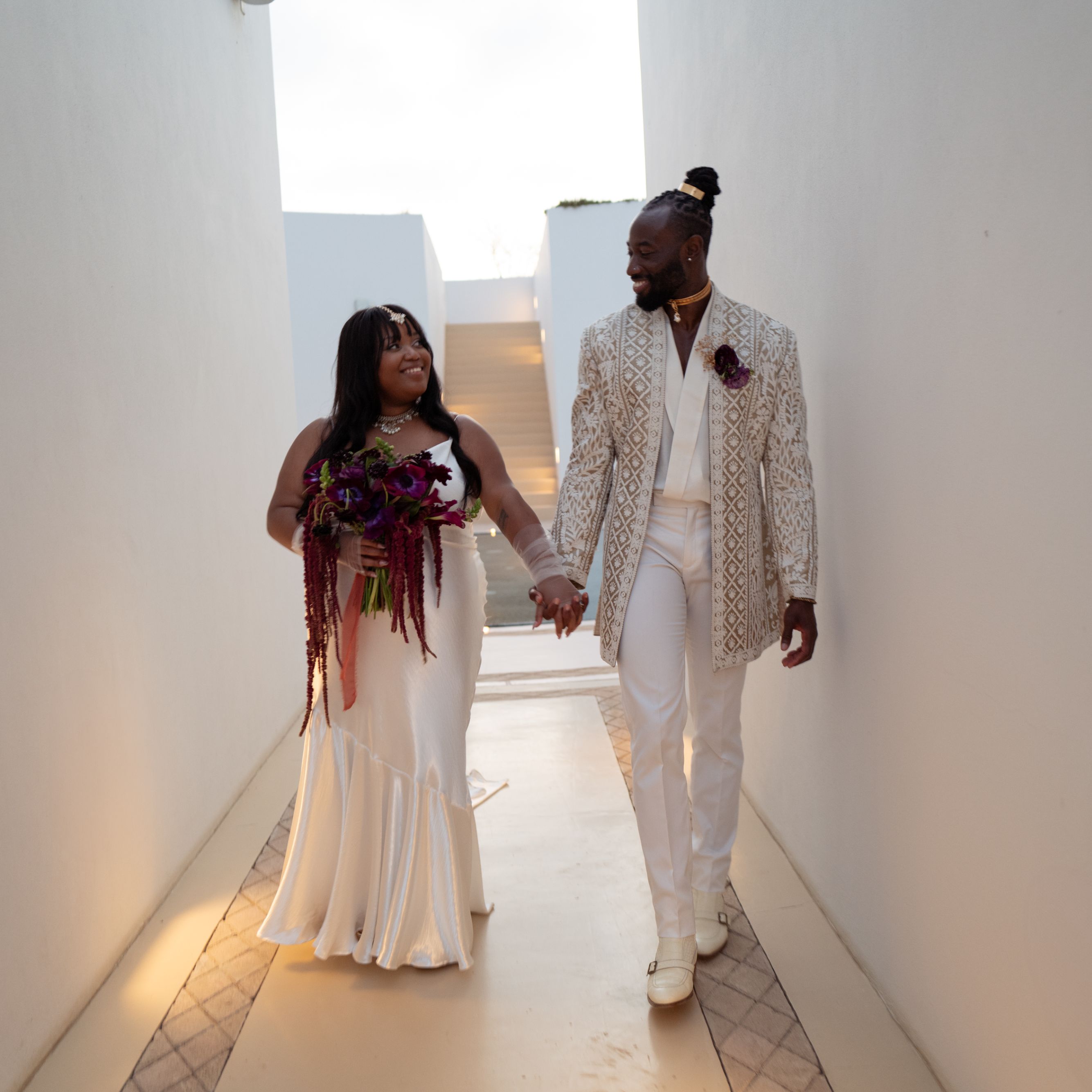 Bride and groom walking hand in hand.