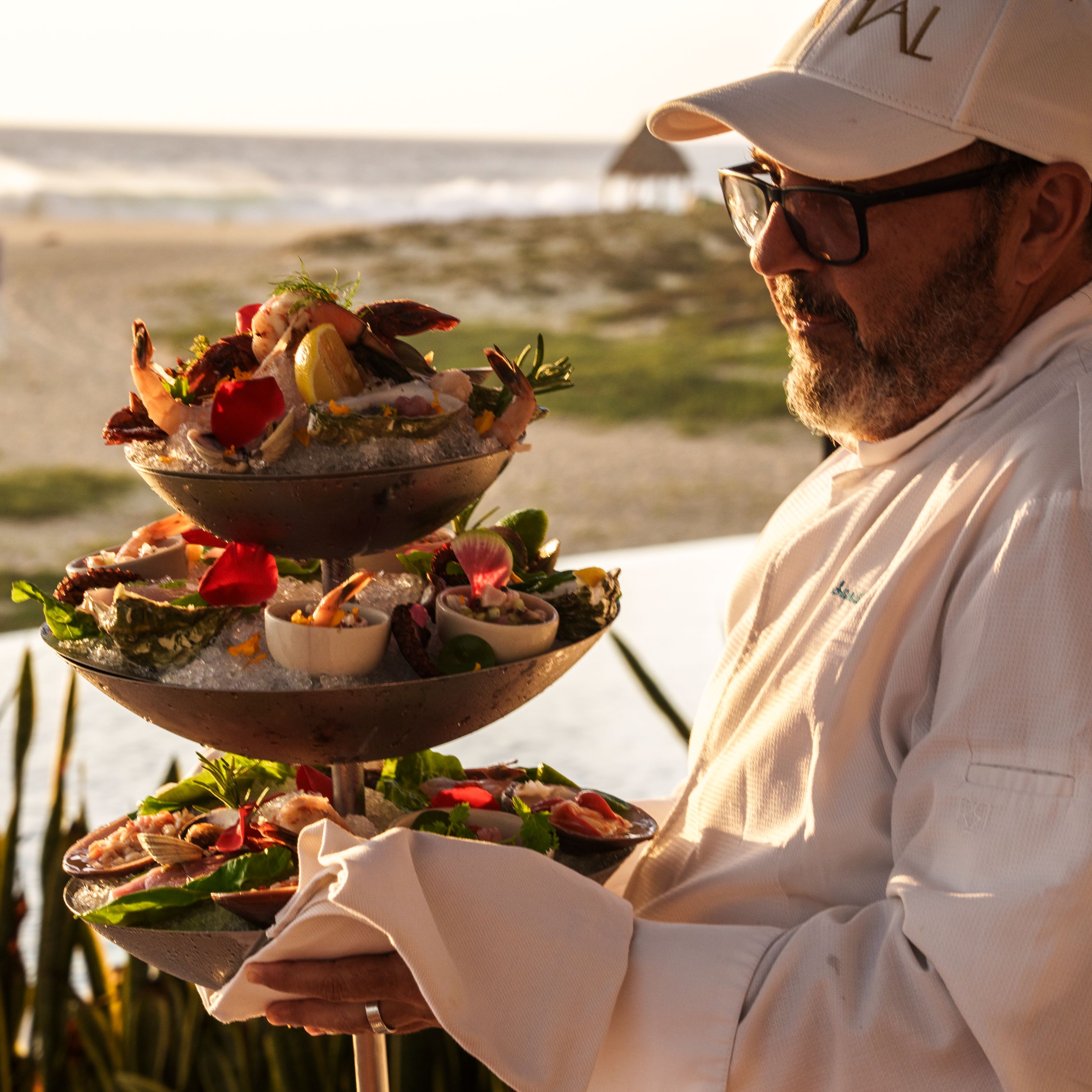 Chef holding up seafood tower.