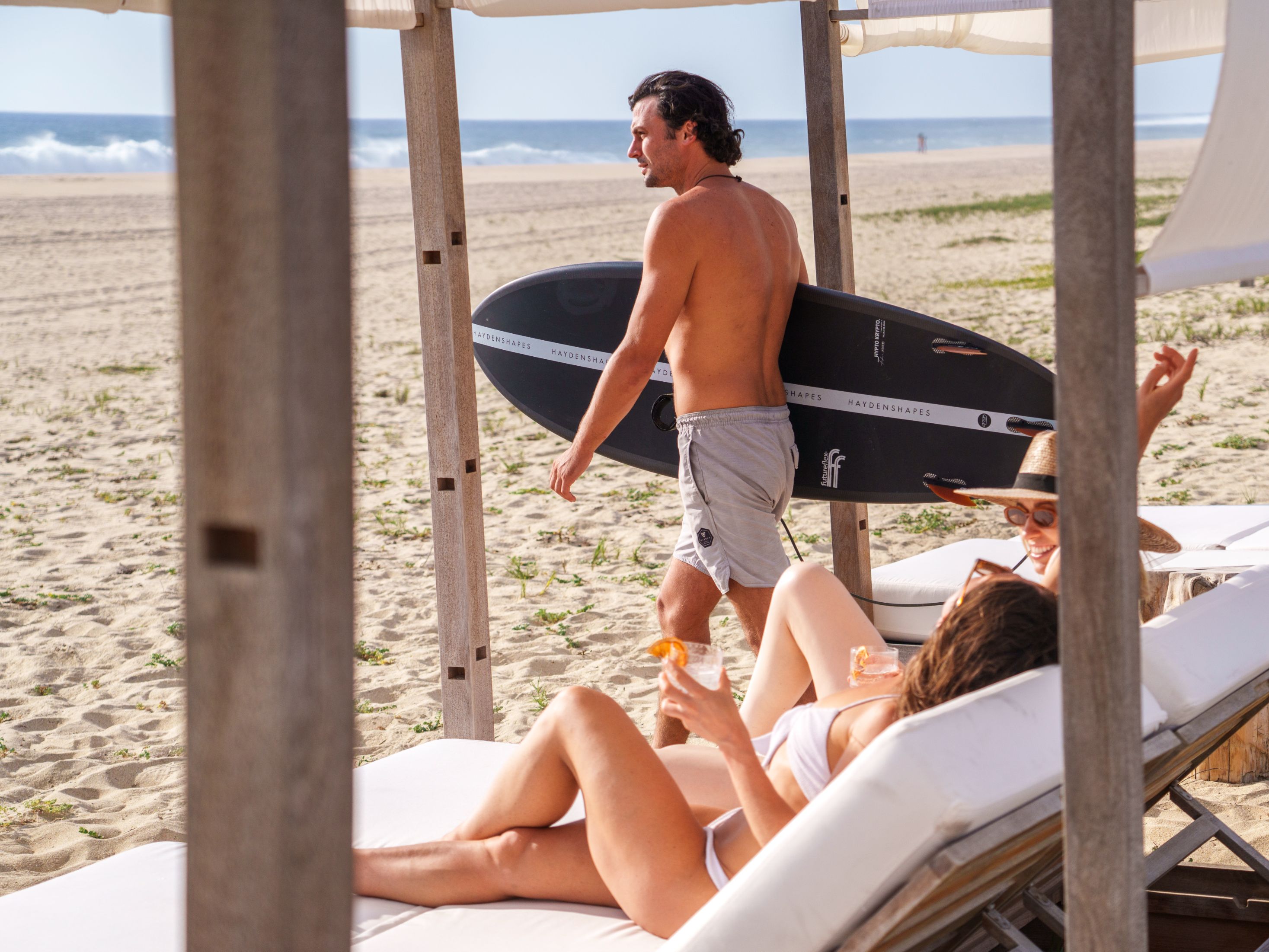 Man holding a surfboard on the beach.