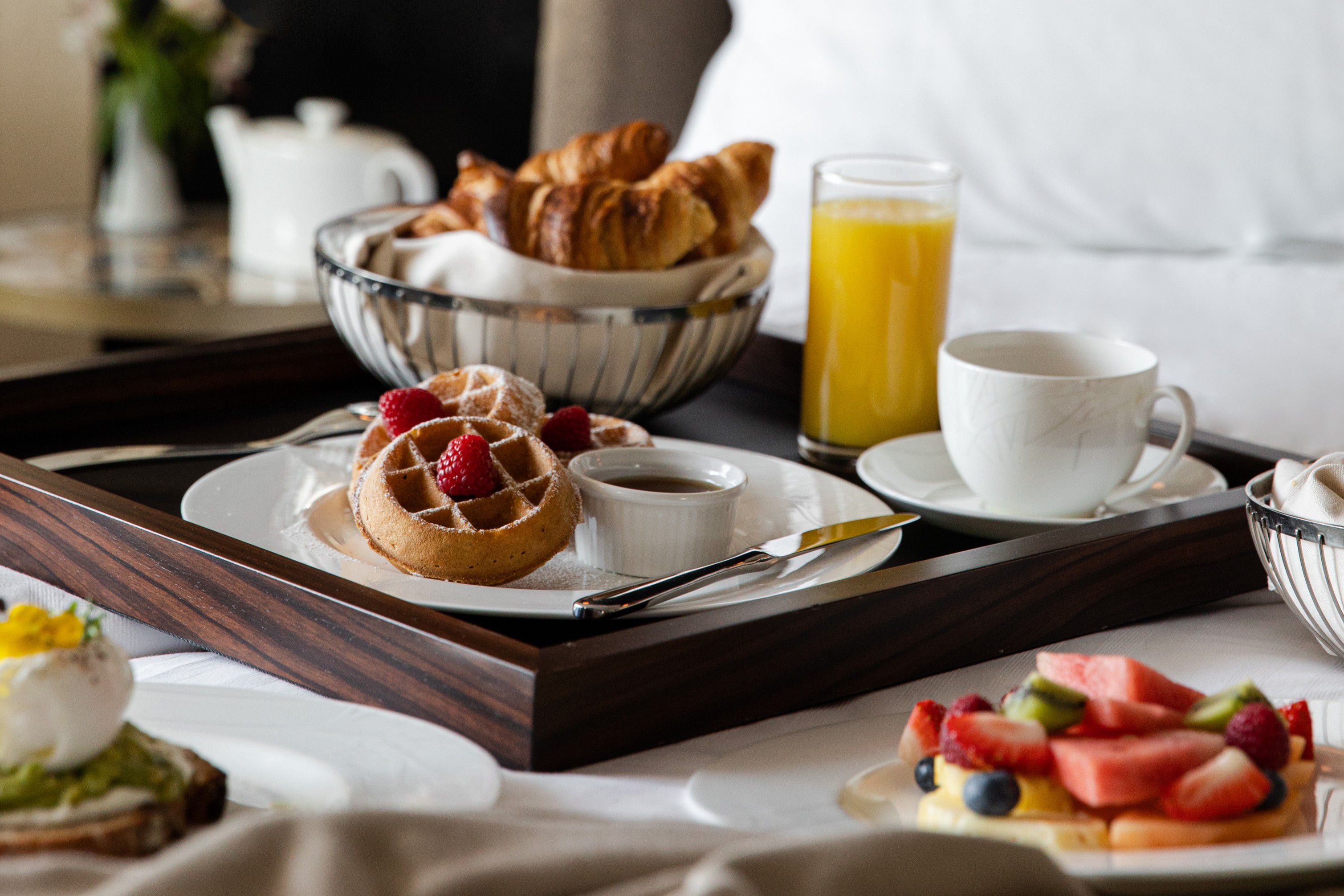 in-room dining with breakfast spread on bed