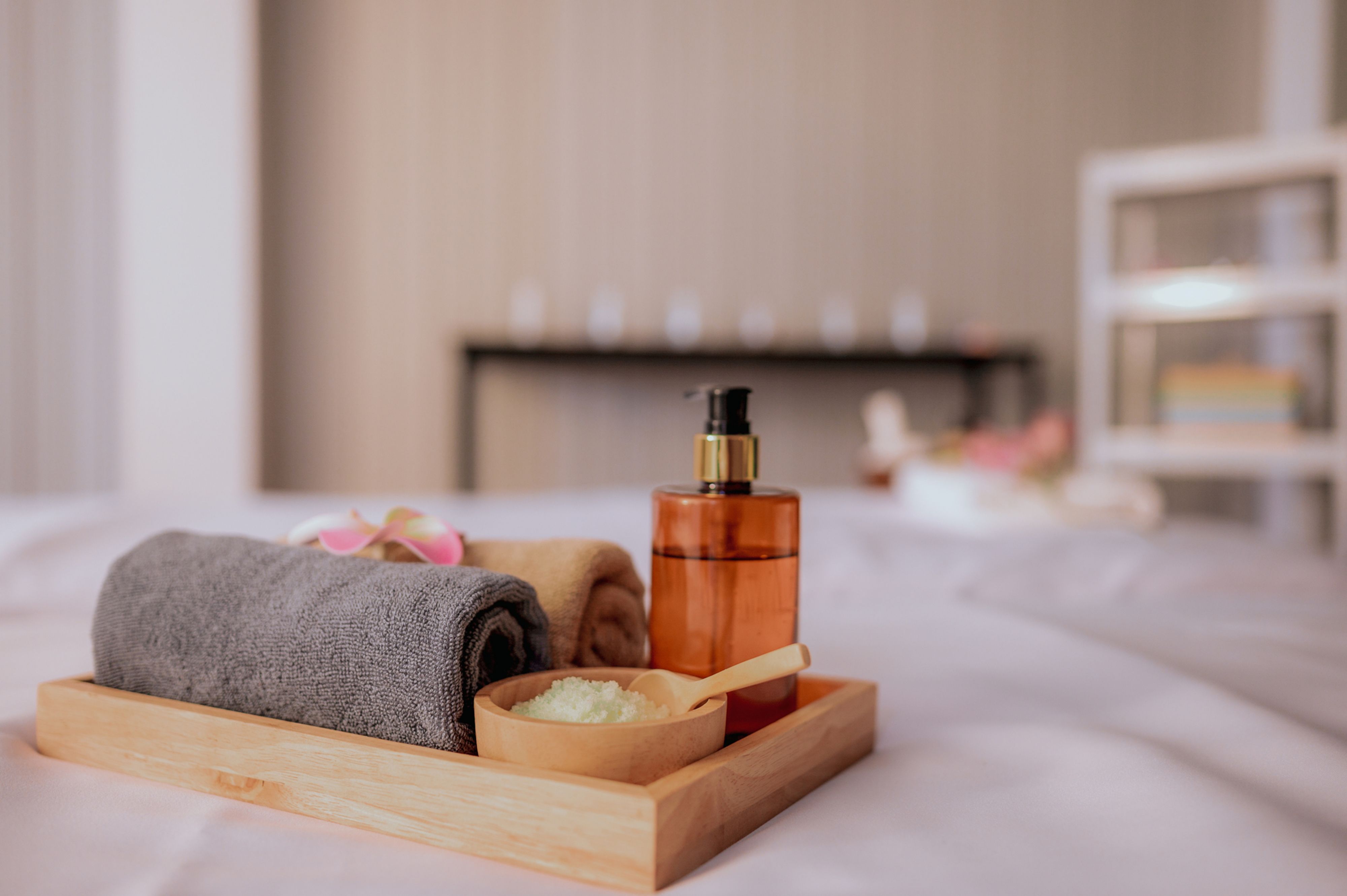 Beautiful spa composition on massage table in wellness center. Aromatherapy, oriental massage and spa treatment. Relaxation composition of towels, candles, flowers, stones and herbal balls.