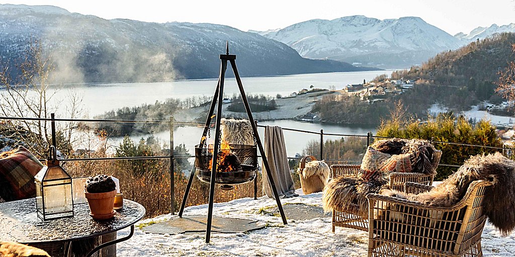 Outdoor firepit overlooking a lake and snow capped mountains