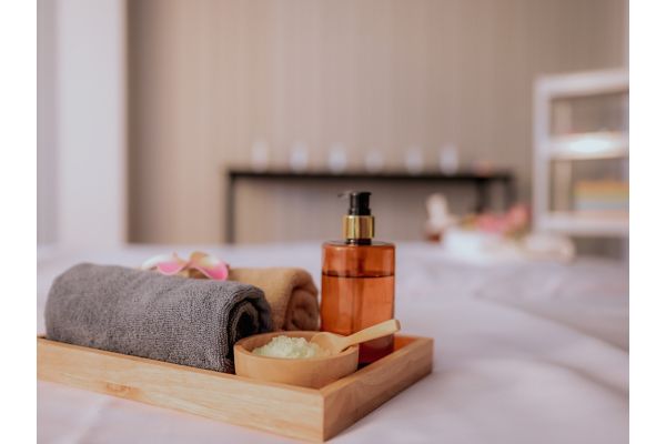 Spa amenities with rolled towels and massage oil