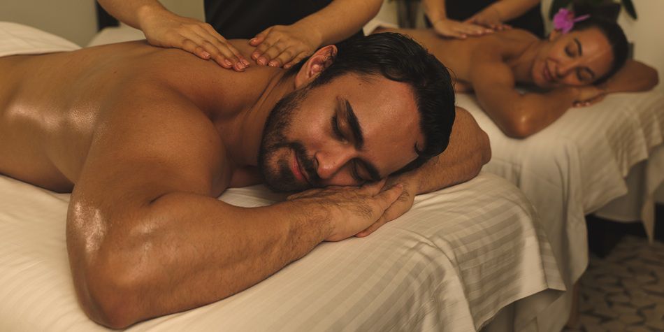 Couples massage with therapists performing back therapy