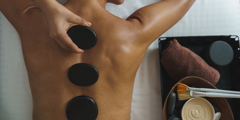 Hot stone back massage with towels and spa tools