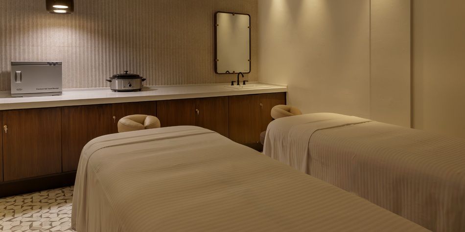 Dual spa treatment room with massage tables and storage