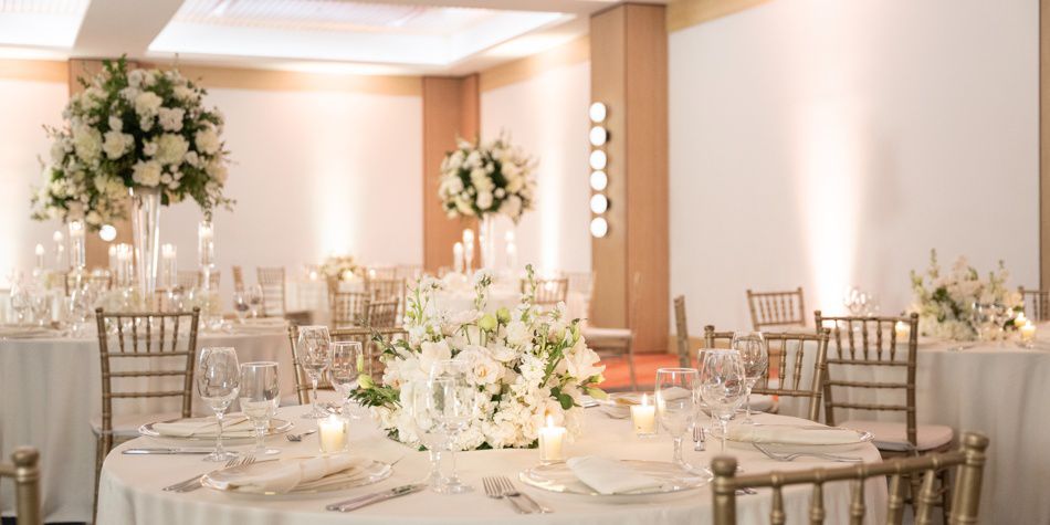 Elegante lugar para celebrar bodas con mesas redondas y centros de mesa florales