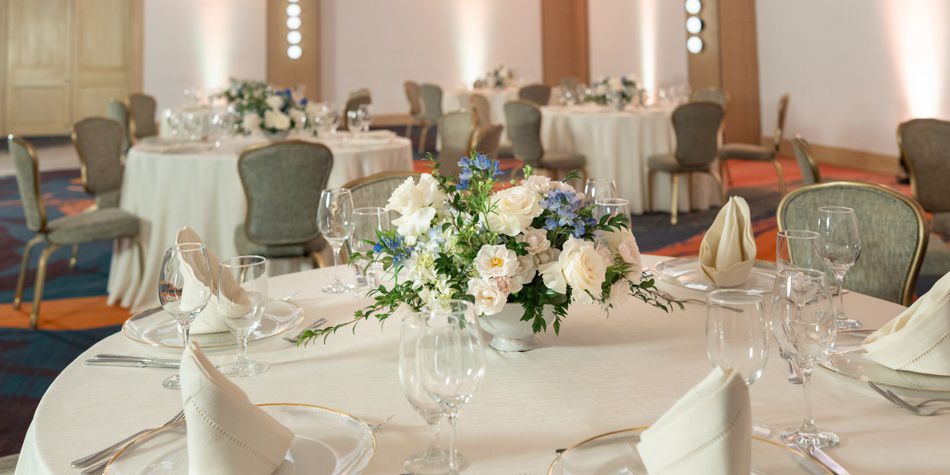 Mesa de banquete larga con arreglos florales y cubiertos