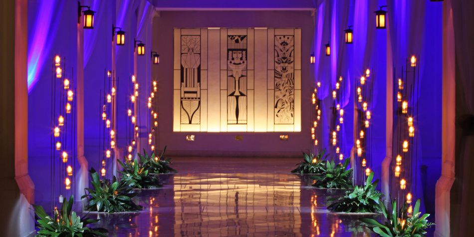 Espacio para la ceremonia de bodas con iluminación púrpura y pasillo iluminado con velas