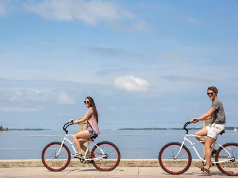 Couple riding bikes on bridge overlooking a bay